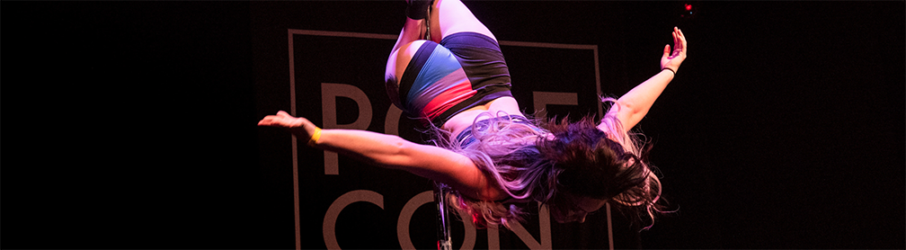 Pole dancer inverted on stage.