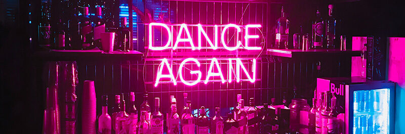 Neon sign reading: Dance Again.