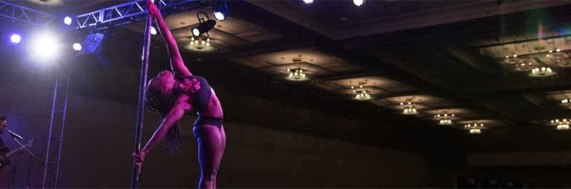 Pole Dancer Sets Up For A Move On Stage.