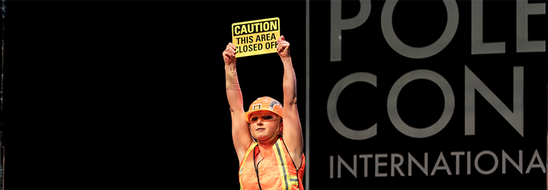 Pole Dancer In Hard Hat With Caution Sign Dances On Stage.