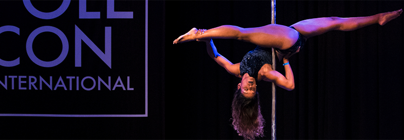 A Woman Of Color Executes A Jade Split On A Pole On The PoleCon Stage.